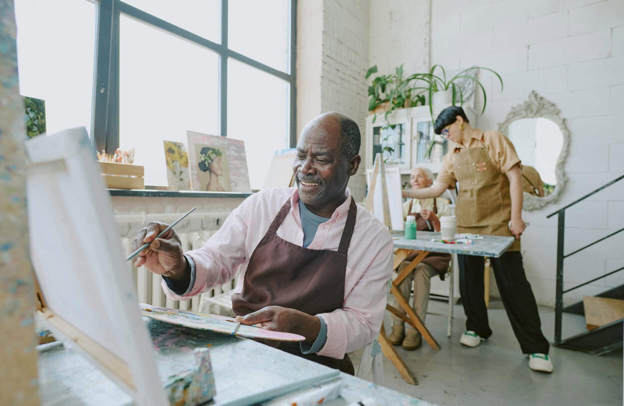A man enjoys painting during art therapy in Massachusetts.
