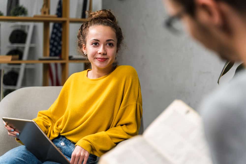 Students studying with a book and tablet while receiving support from drug rehab for students in Massachusetts at Brook Recovery Centers.
