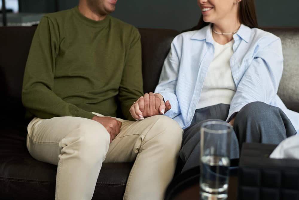 Man and woman holding hands during a therapy session after relapse.