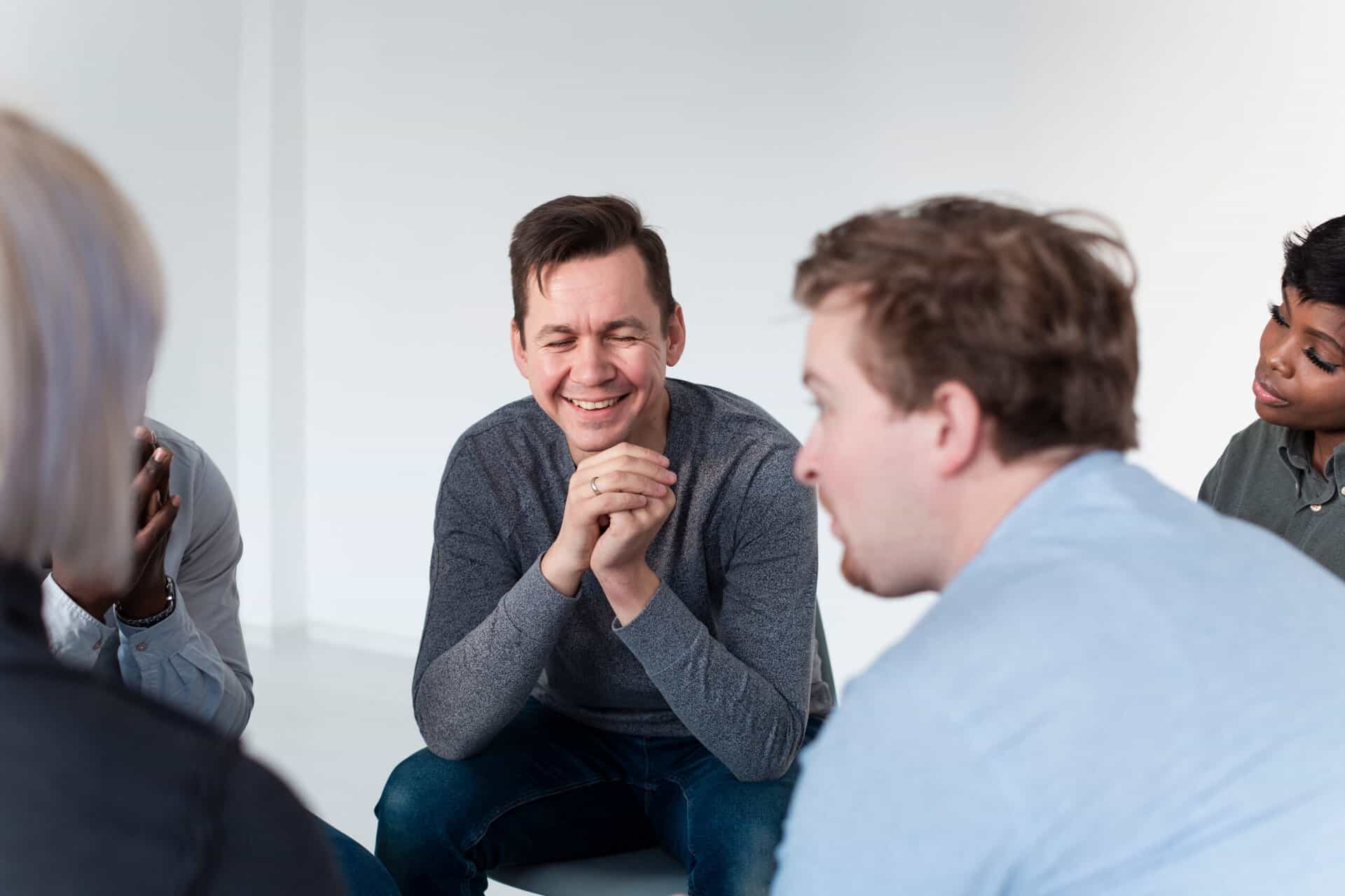 A man enjoys a group exercise during bipolar disorder and addiction treatment in Massachusetts.