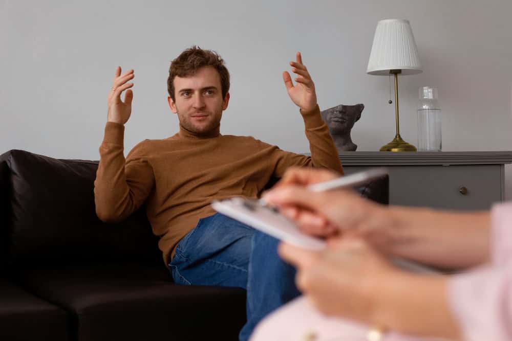 Man participating in therapy to discuss ADHD medication and whether Adderall is addictive when prescribed.