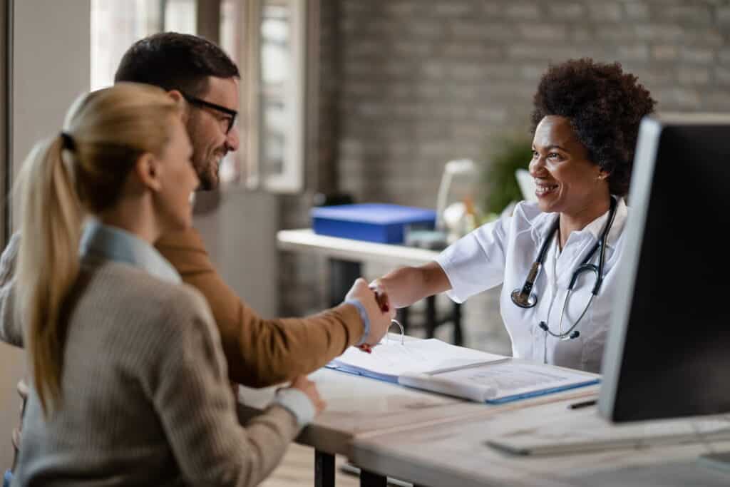 A couple inquires about rehabs that take UMR insurance during a consultation with their doctor.